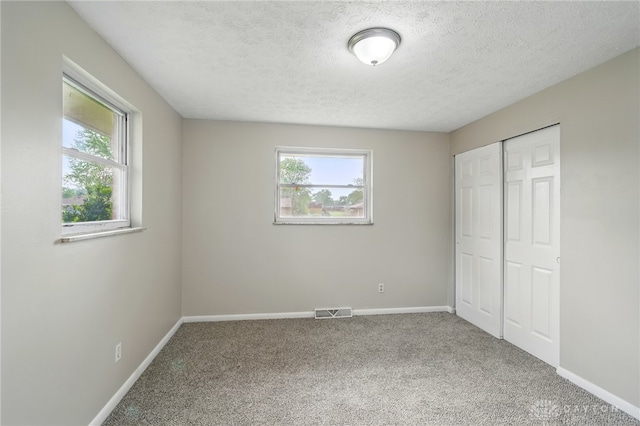 59 Janet Ave, Carlisle, OH 45005 - unfurnished bedroom featuring carpet floors, a textured ceiling, visible vents, and a closet