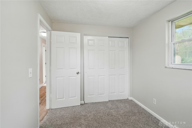 59 Janet Ave, Carlisle, OH 45005 - unfurnished bedroom featuring a closet, carpet, a textured ceiling, and baseboards