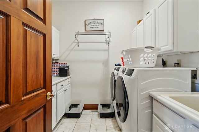 laundry room featuring washer and clothes dryer, cabinet space, and marble finish floor