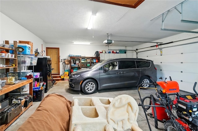 garage featuring freestanding refrigerator and a garage door opener