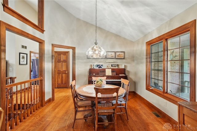 dining space with visible vents, light wood finished floors, and an inviting chandelier
