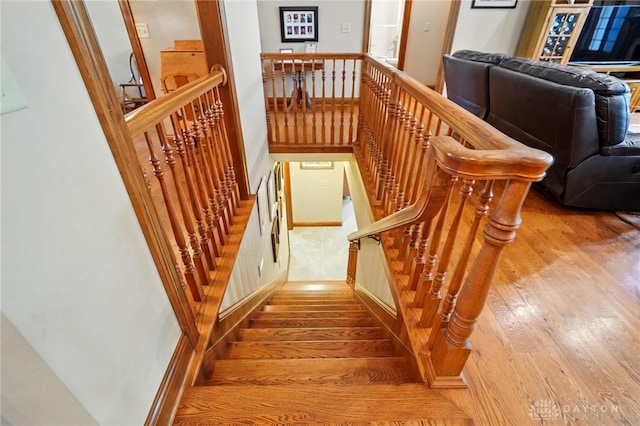 stairs featuring wood finished floors