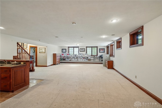 hallway featuring recessed lighting, baseboards, light carpet, and stairway