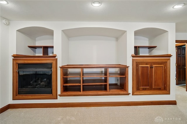 carpeted living area with baseboards, a fireplace, and recessed lighting