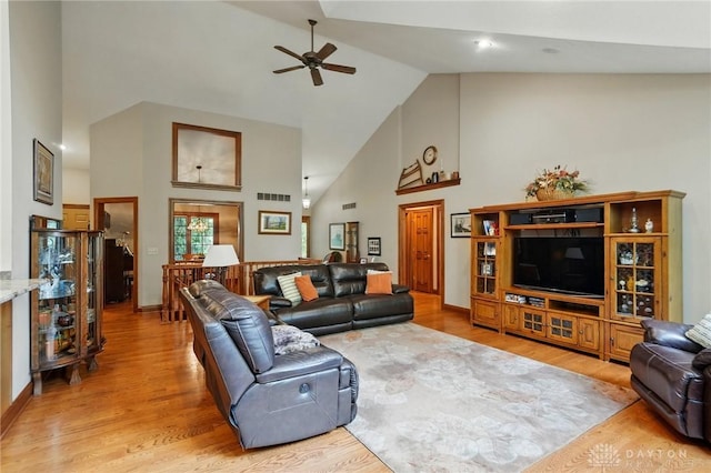 living room with ceiling fan, visible vents, high vaulted ceiling, baseboards, and light wood-style floors