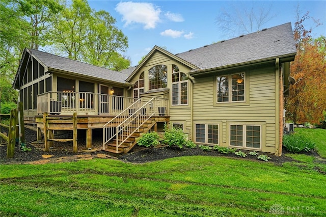 rear view of property with roof with shingles, stairs, a wooden deck, a sunroom, and a yard