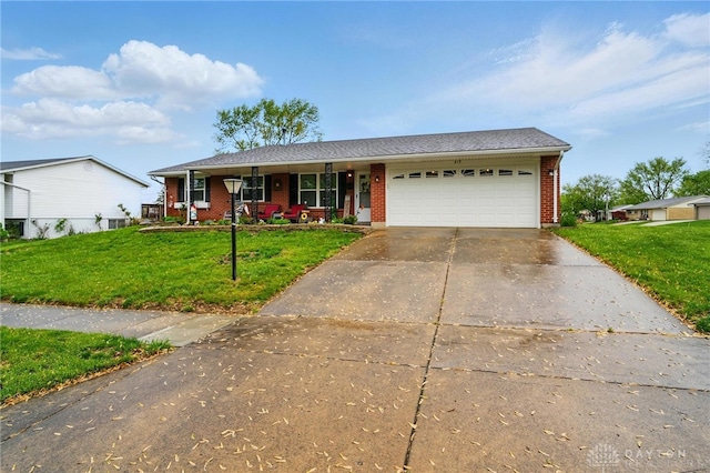 317 Ironwood Dr, West Carrollton, OH 45449 - ranch-style house with brick siding, covered porch, concrete driveway, and a front lawn