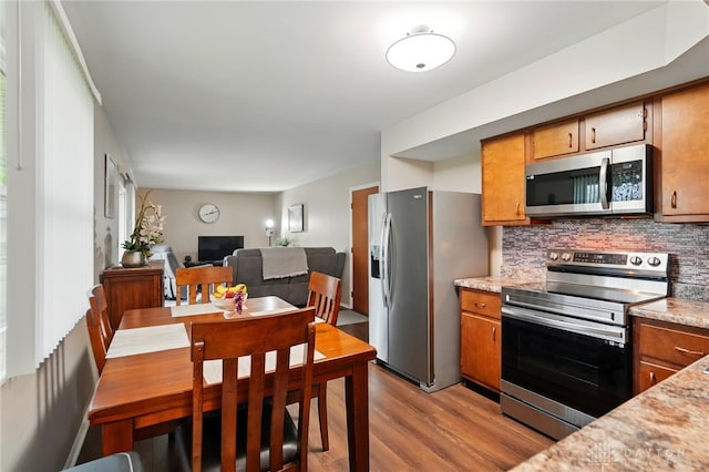 317 Ironwood Dr, West Carrollton, OH 45449 - kitchen featuring appliances with stainless steel finishes, brown cabinets, and wood finished floors