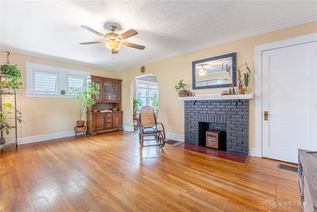 19 Klee Ave, Dayton, OH 45403 - living area with a fireplace, light wood-type flooring, arched walkways, ceiling fan, and ornamental molding