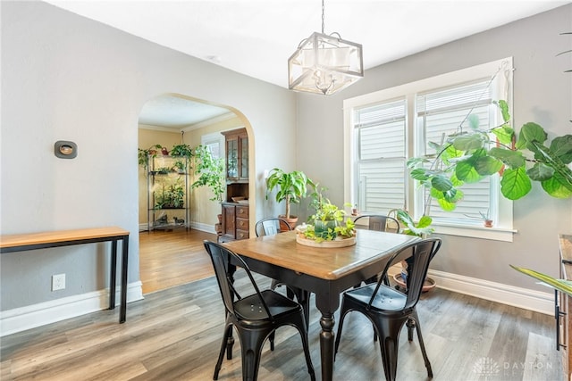 19 Klee Ave, Dayton, OH 45403 - dining area featuring arched walkways, a chandelier, and wood finished floors