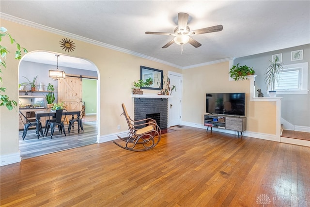 19 Klee Ave, Dayton, OH 45403 - living room featuring a barn door, hardwood / wood-style floors, a ceiling fan, a fireplace, and arched walkways