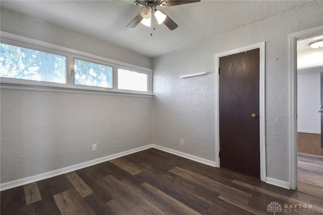 unfurnished bedroom featuring baseboards, a ceiling fan, a textured wall, and wood finished floors