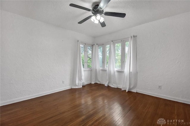 unfurnished room featuring a ceiling fan, baseboards, a textured wall, and hardwood / wood-style flooring