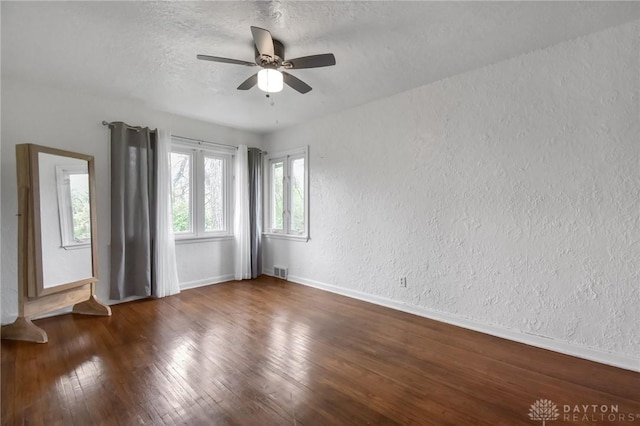 empty room featuring visible vents, baseboards, ceiling fan, and a textured wall