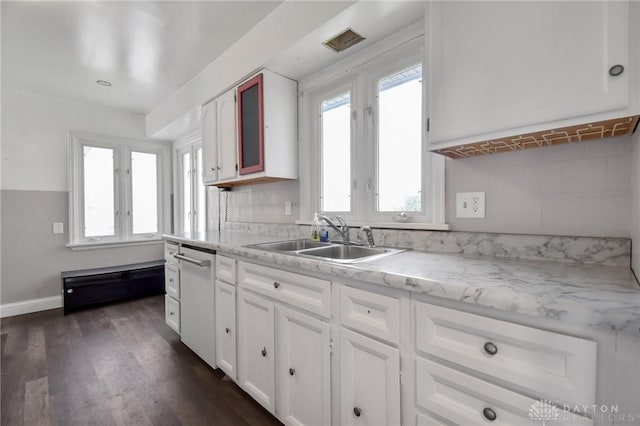 kitchen featuring dark wood-style flooring, baseboards, white cabinets, a sink, and dishwasher