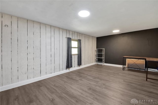 spare room featuring baseboards and wood finished floors