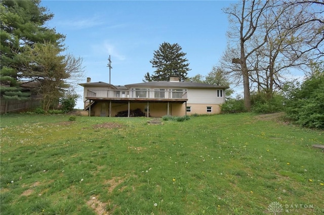 back of house with fence, a chimney, a yard, and a deck