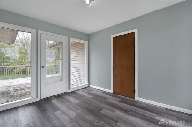 doorway to outside with dark wood-style flooring and baseboards
