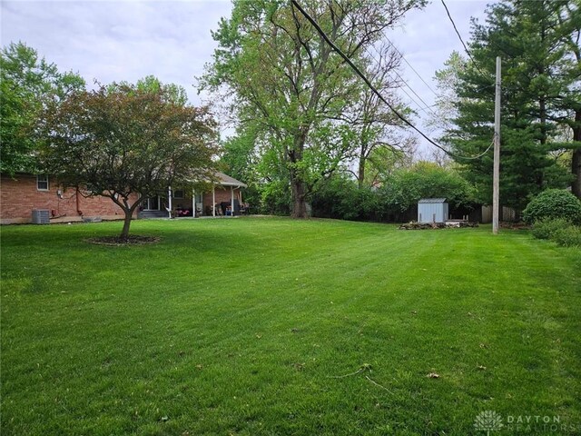 403 W Rahn Rd, Dayton, OH 45429 - view of yard featuring central AC, an outdoor structure, and a storage unit