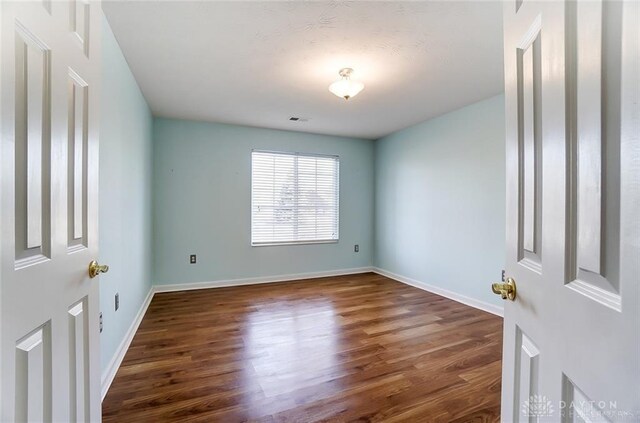 3087 Westminster Dr Unit 101, Beavercreek, OH 45431 - spare room featuring baseboards, dark wood-style flooring, and visible vents