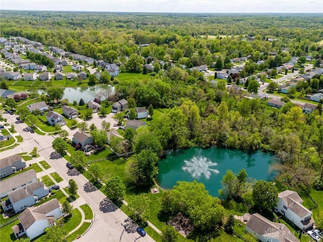 aerial view featuring a water view, a view of trees, and a residential view