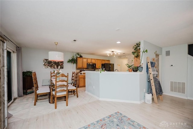 dining room with light wood-style floors, baseboards, and visible vents