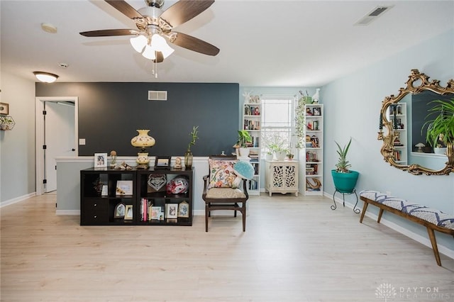 sitting room featuring visible vents, a ceiling fan, and wood finished floors