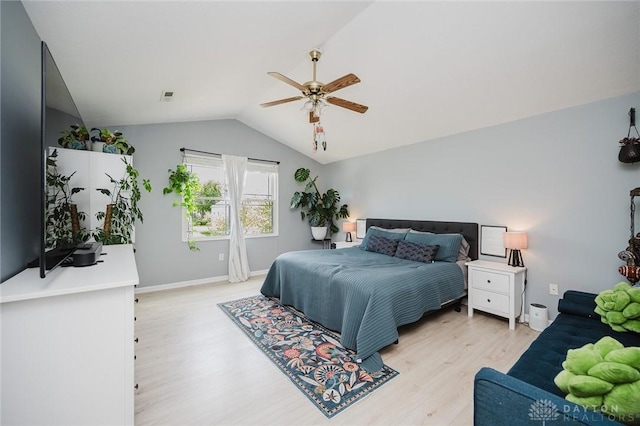 bedroom with light wood finished floors, a ceiling fan, baseboards, lofted ceiling, and visible vents