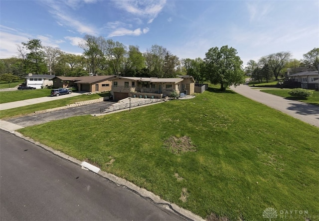view of front of property with a garage, a front lawn, and driveway