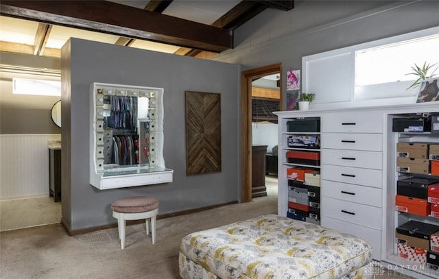 carpeted bedroom with beam ceiling
