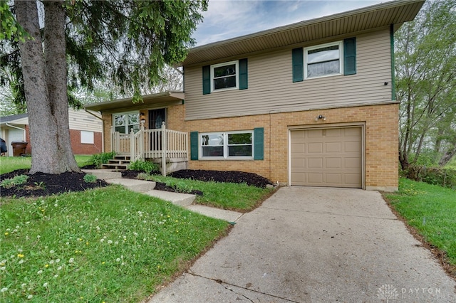 tri-level home featuring concrete driveway, brick siding, an attached garage, and a front lawn