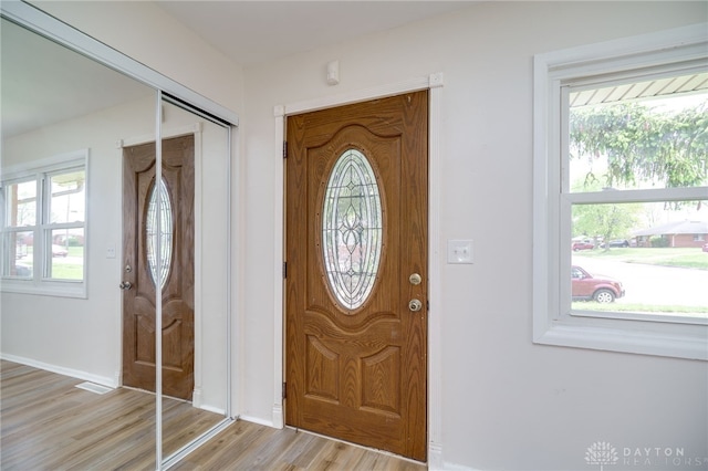 entryway featuring baseboards, plenty of natural light, and light wood-type flooring