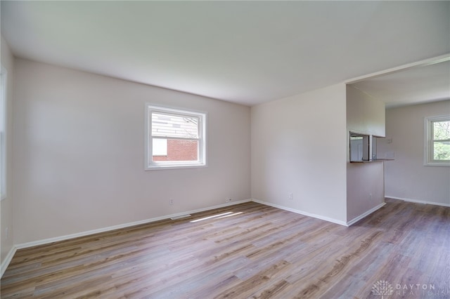 spare room with baseboards, visible vents, and light wood finished floors