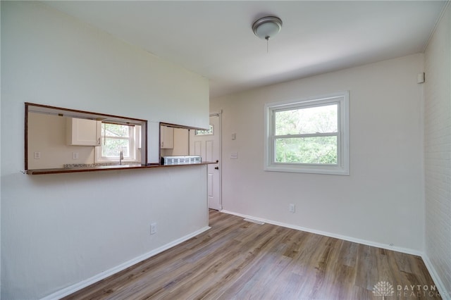 spare room with baseboards and wood finished floors