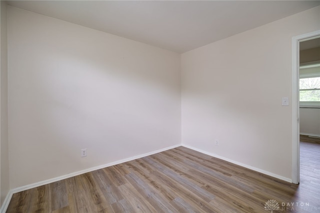 empty room with baseboards and wood finished floors