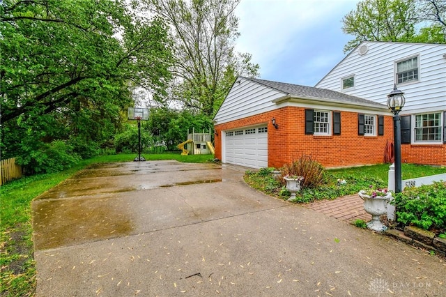 5788 Folkestone Dr, Dayton, OH 45459 - view of side of home with brick siding, driveway, and a garage