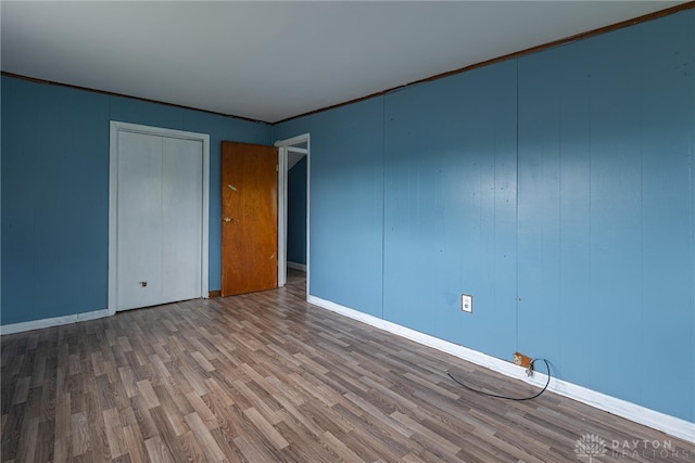unfurnished room with baseboards and wood finished floors