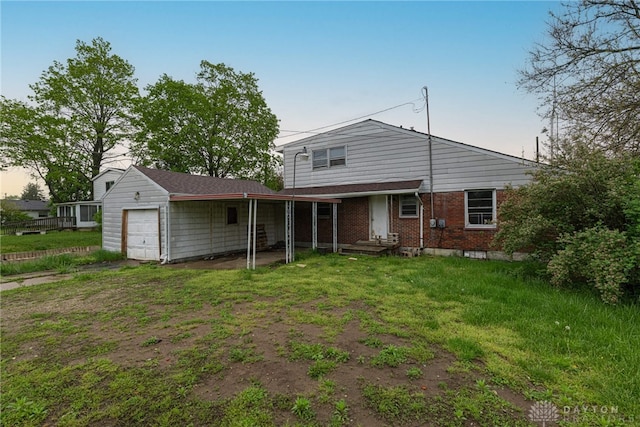 rear view of house featuring an attached garage, a lawn, and brick siding