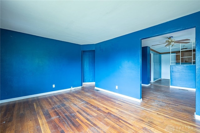 spare room with baseboards, ceiling fan, and hardwood / wood-style floors