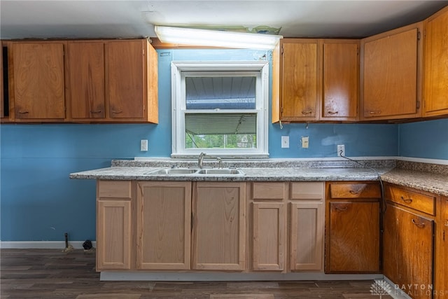 kitchen featuring light countertops, dark wood finished floors, and a sink
