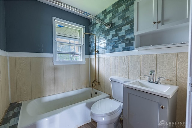bathroom featuring wainscoting, toilet, shower / tub combination, and vanity