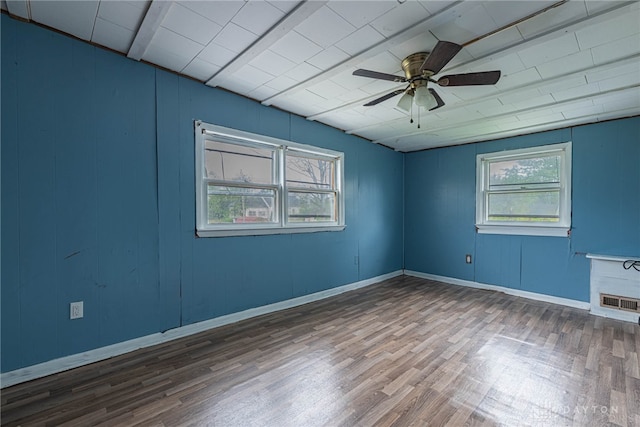 empty room with a ceiling fan, wood finished floors, and visible vents