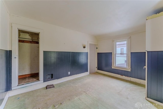 unfurnished living room with a wainscoted wall