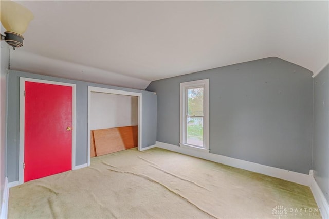 interior space with baseboards, carpet flooring, and lofted ceiling