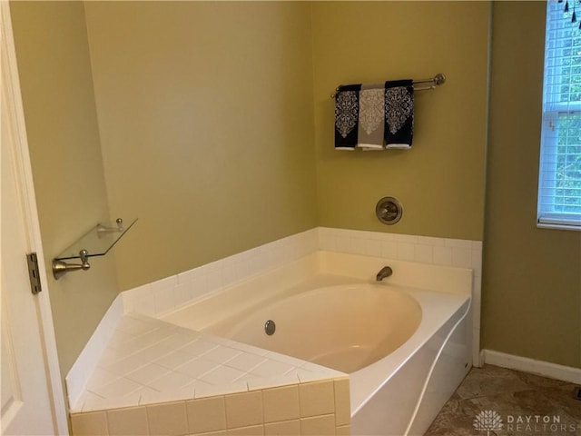bathroom with a garden tub, baseboards, and tile patterned flooring