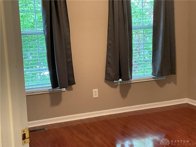 details featuring baseboards, wood finished floors, and visible vents