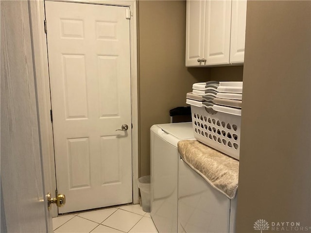 washroom with light tile patterned floors, cabinet space, and washer and dryer