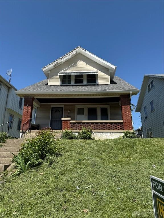 1080 Linden Ave, Dayton, OH 45410 - view of front of house featuring brick siding, a porch, and a shingled roof