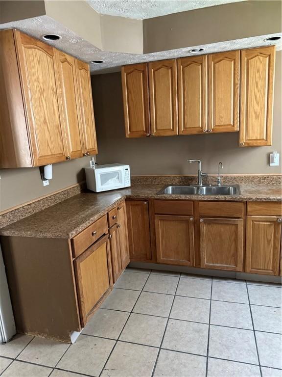 1080 Linden Ave, Dayton, OH 45410 - kitchen with white microwave, a sink, and light tile patterned floors