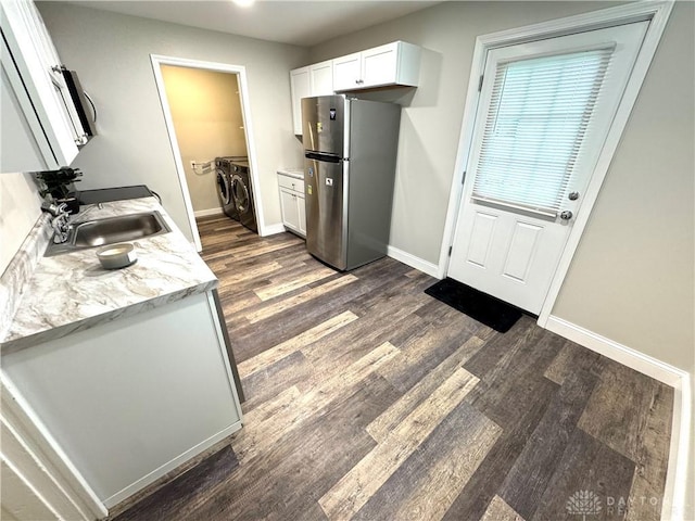 308 Park Ave, Harrison Twp, OH 45030 - kitchen featuring freestanding refrigerator, dark wood-style flooring, light countertops, a sink, and independent washer and dryer